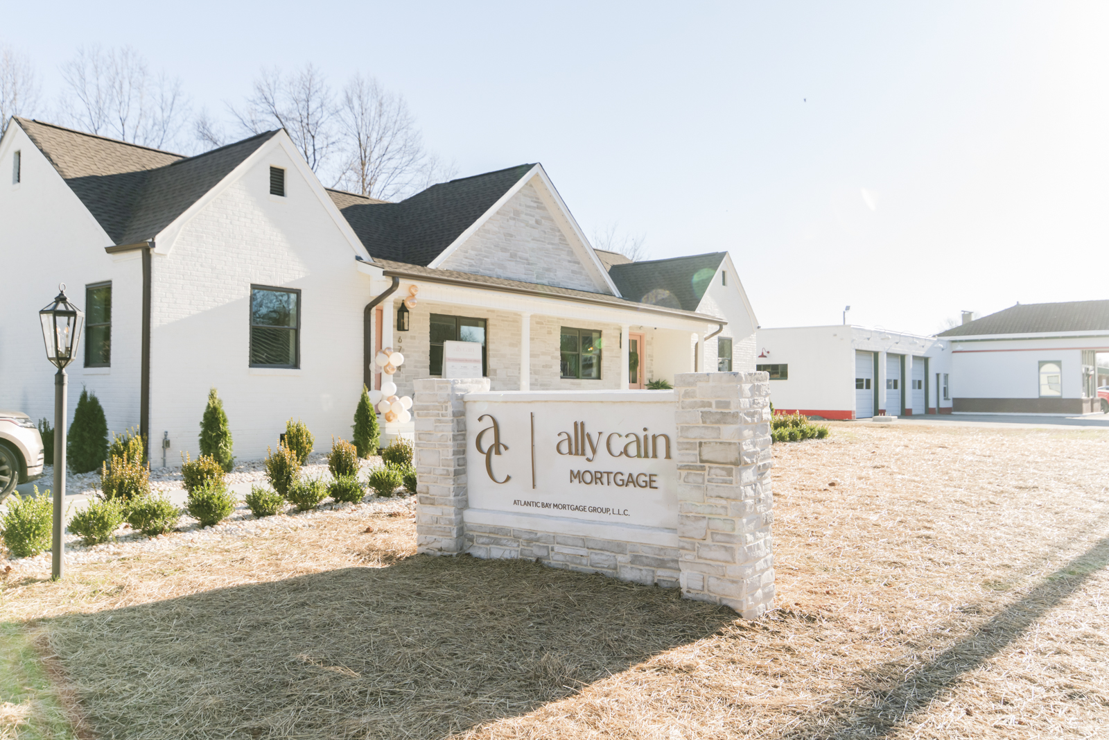 Double-sided outdoor acrylic signage for Ally Cain Mortgage installed on concrete and stone
